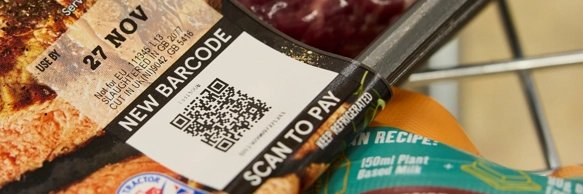 Close-up of a Tesco pack showing a QR code labelled new barcode, scan to pay, alongside a use-by date